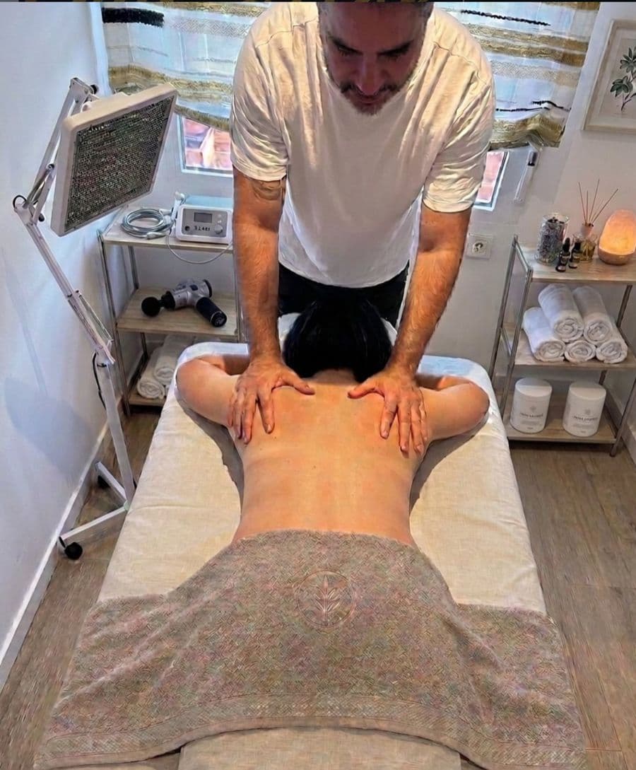 Miguel realizando un quiromasaje en la espalda de un paciente en su clínica de Almussafes